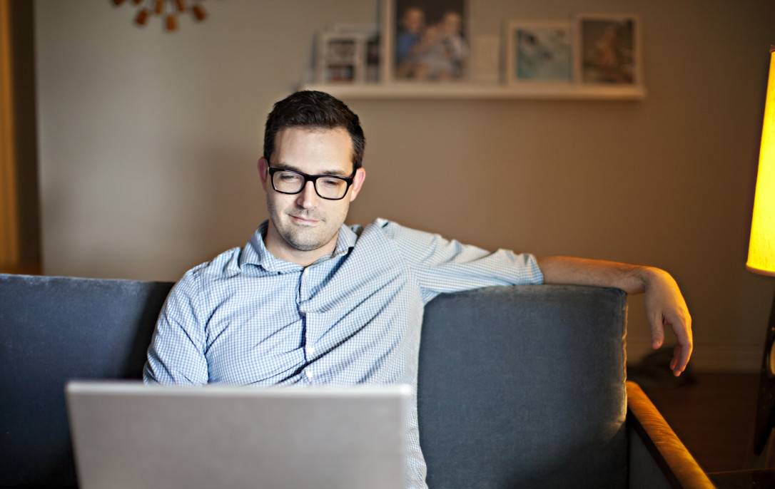man-casually-working-from-home-on-a-laptop-while-sitting-on-a-couch_t20_wKkYar